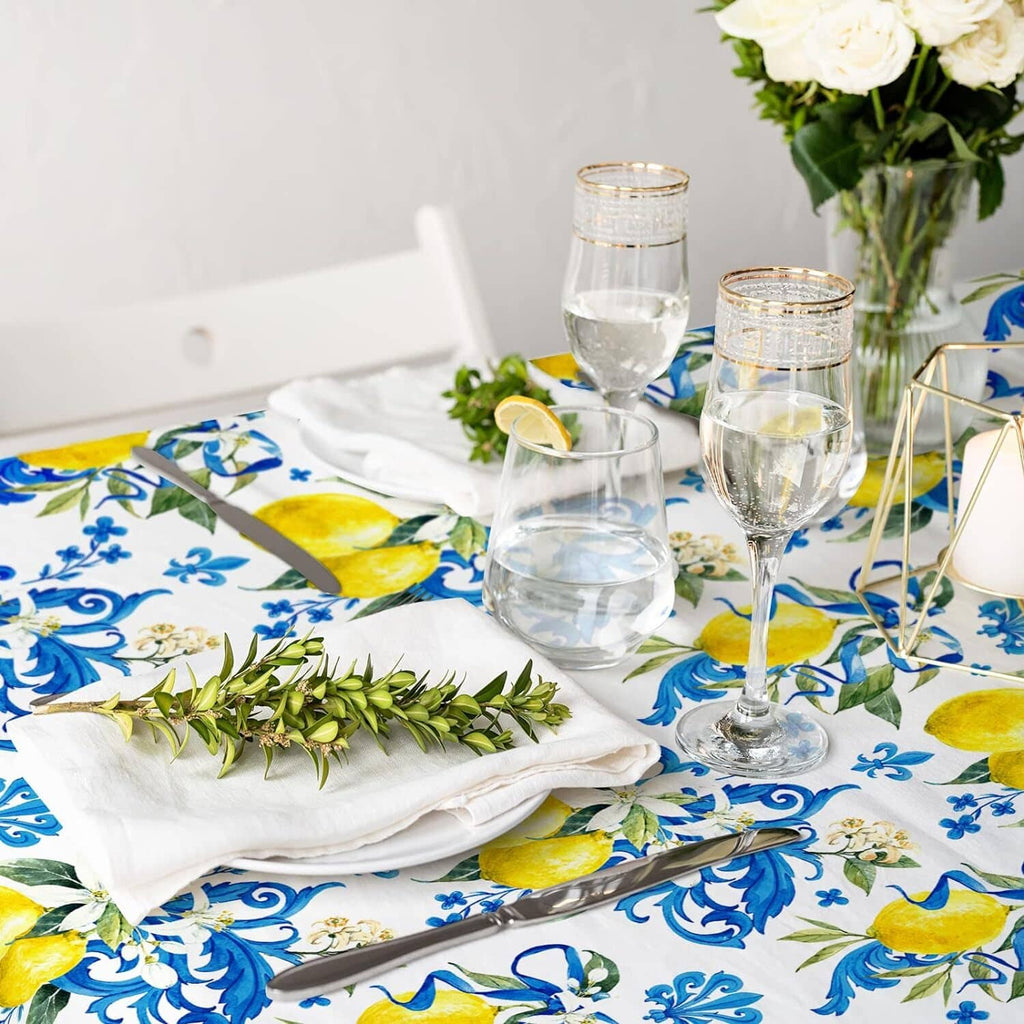 White tablecloth with blue floral swirl and yellow lemon print under dinnerware