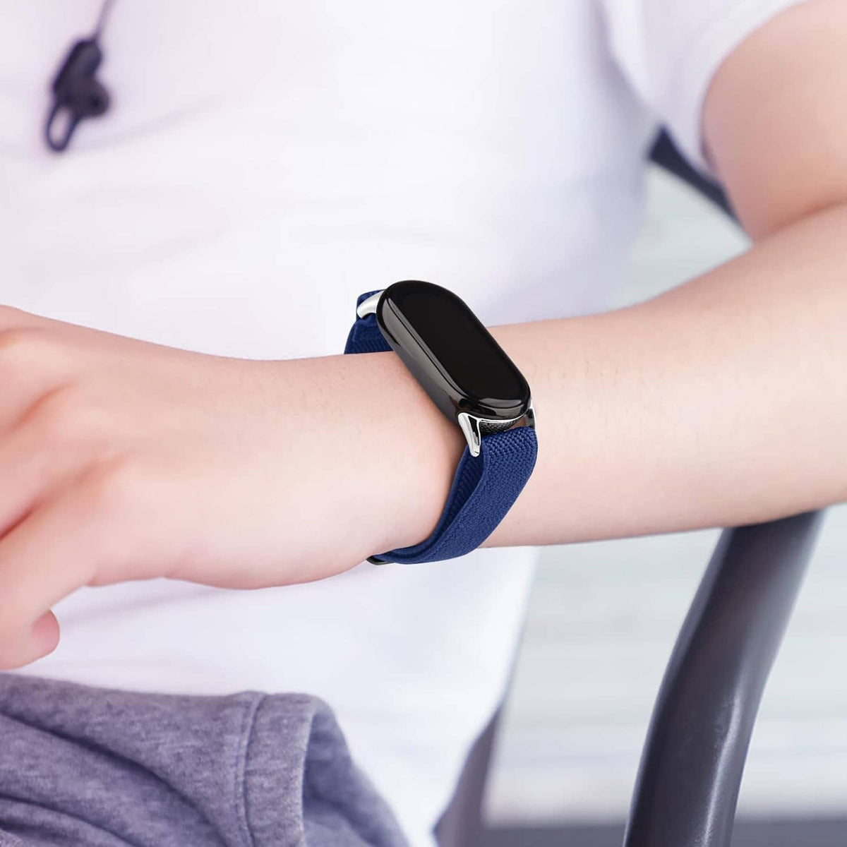 Blue smartwatch band worn on wrist with metal clasp and strap