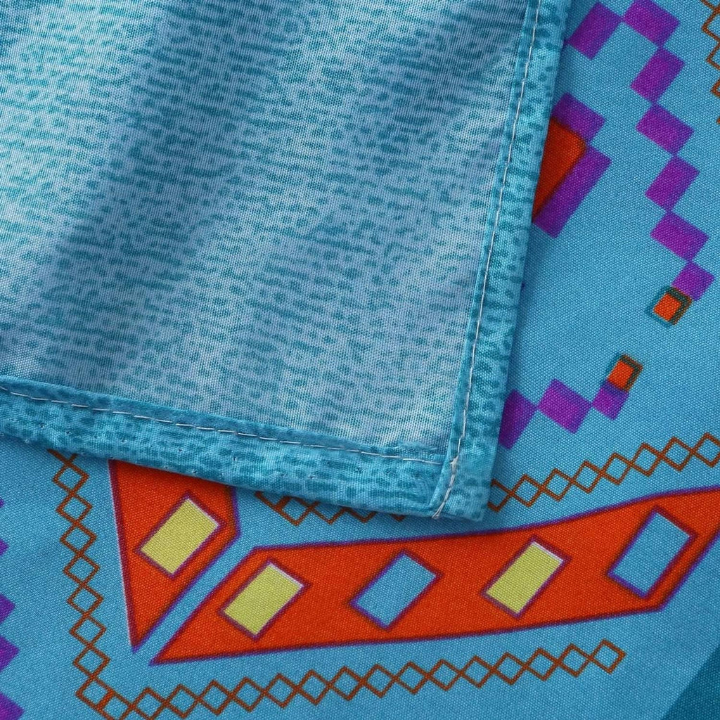 Close-up of stitched fabric edge with light blue and geometric patch pattern