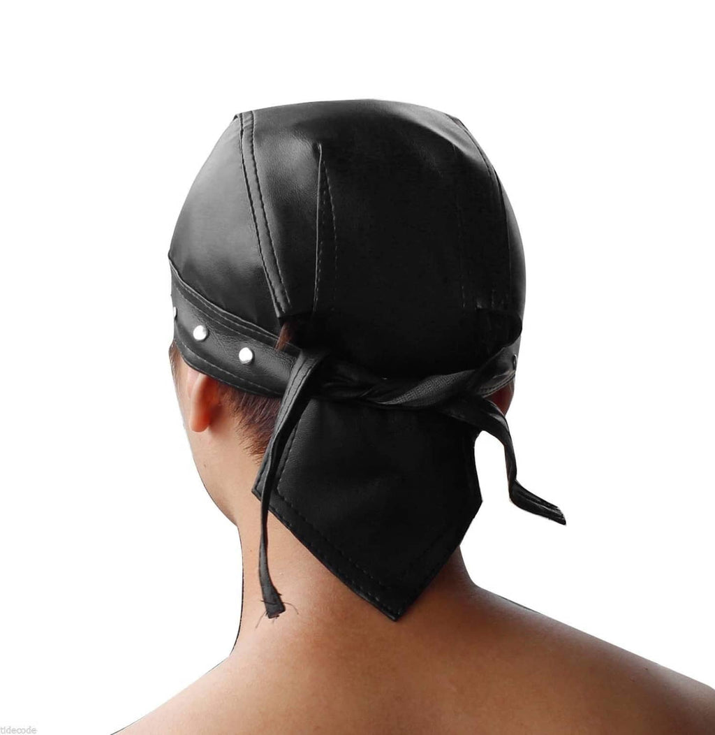 Black skull cap worn with side tie drape and stud band, emblem on front