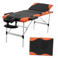 Orange and black adjustable massage table with padded headrest, arm support, and steel frame