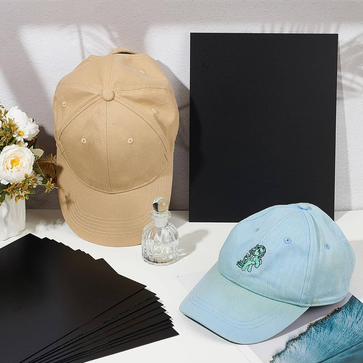 Black rectangular brim insert sheets beside light blue and beige caps