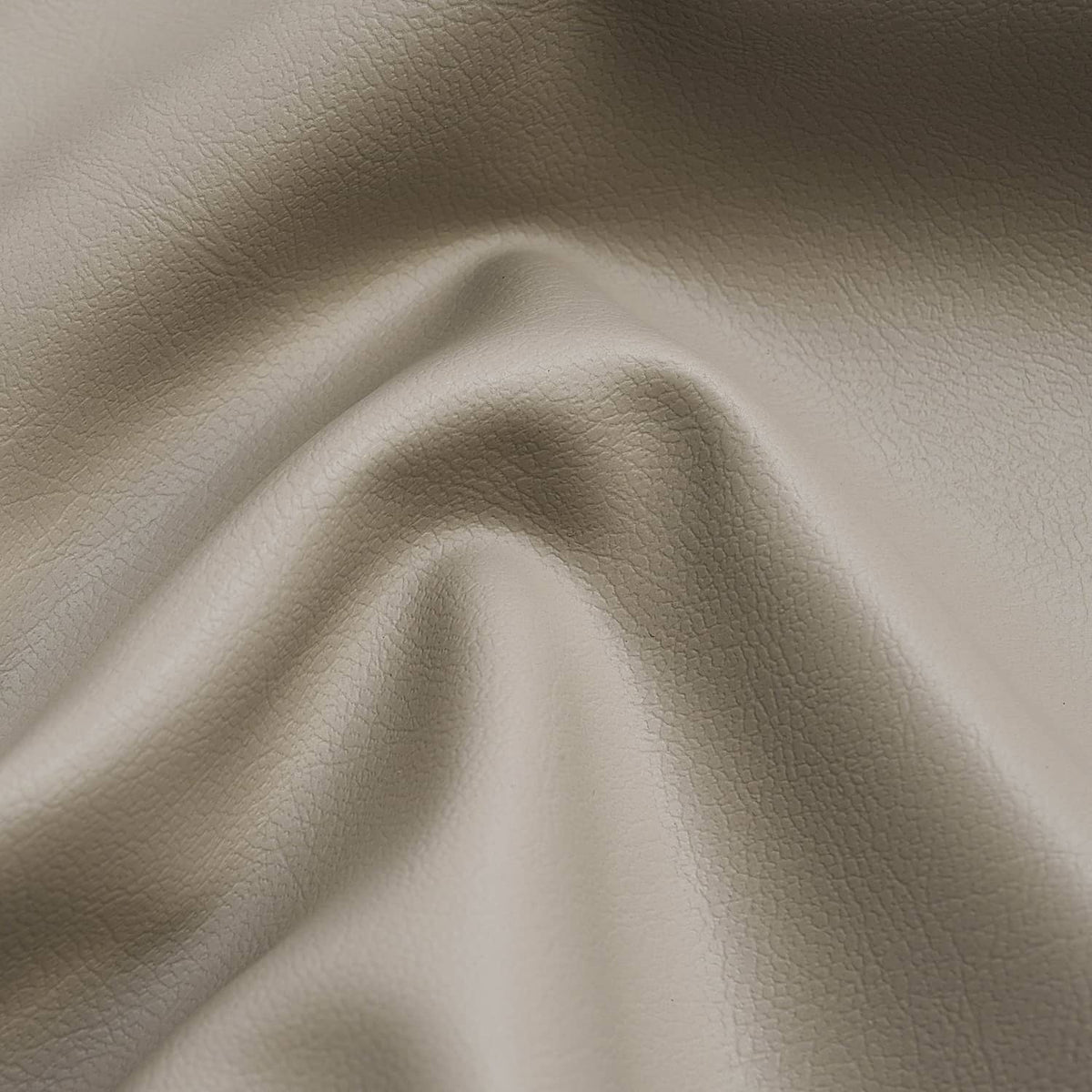 Tan faux leather seat cover with raised grain texture and soft creasing.
