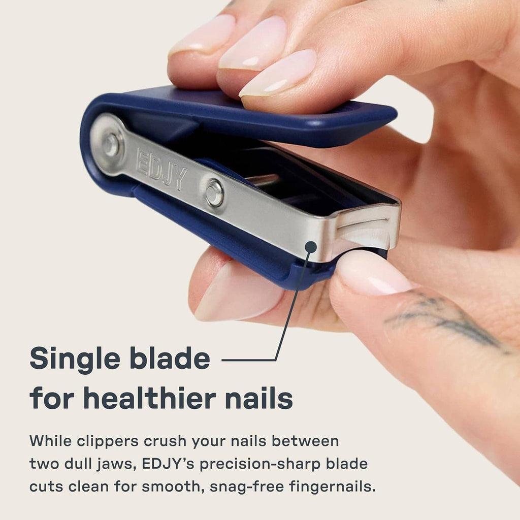 Navy finger nail clipper held in hand with single precision cutting blade