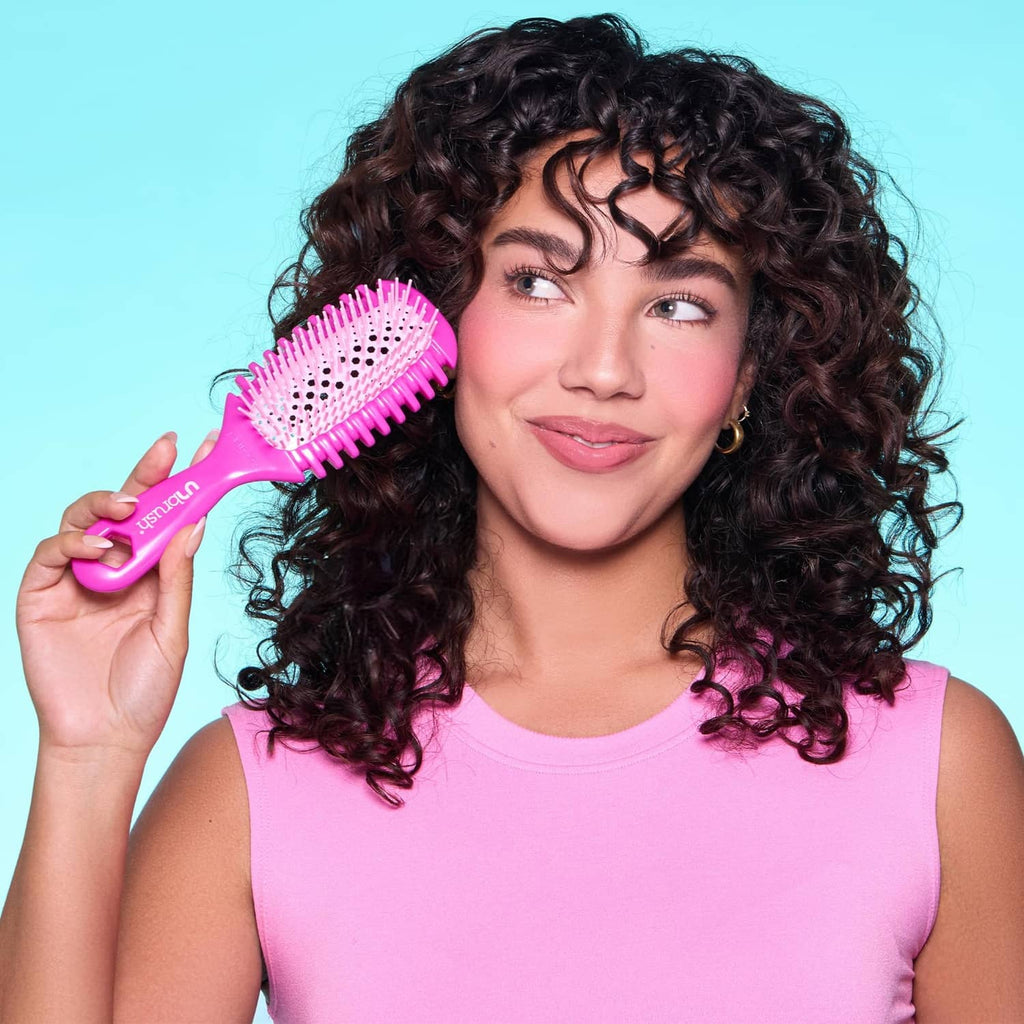 Pink curl brush with white-tipped bristles and shaped ergonomic handle