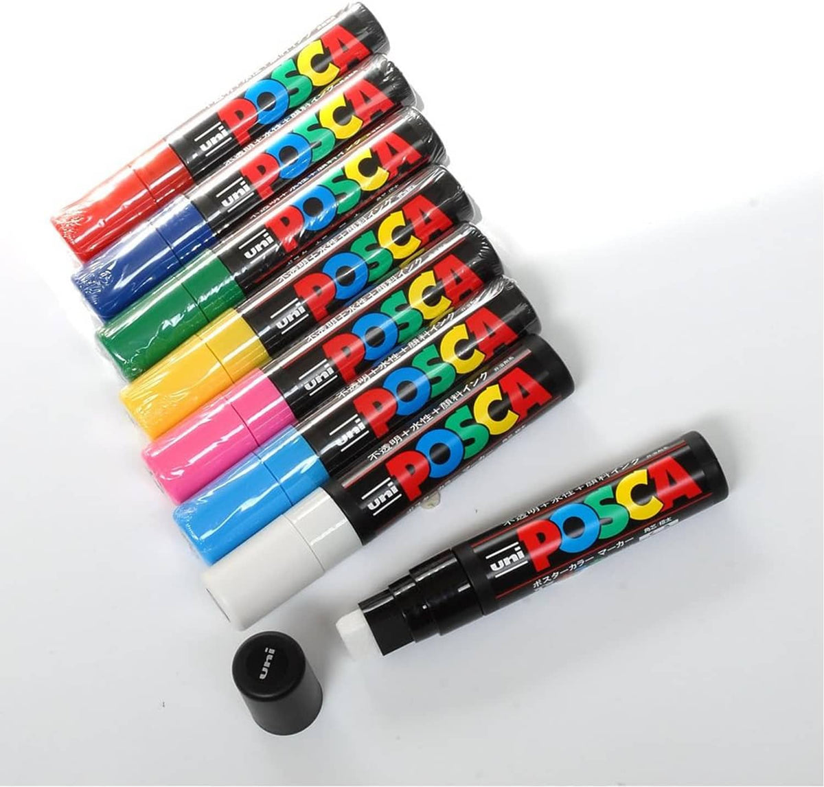 Uni Posca paint markers set with multiple colors and one black marker uncapped