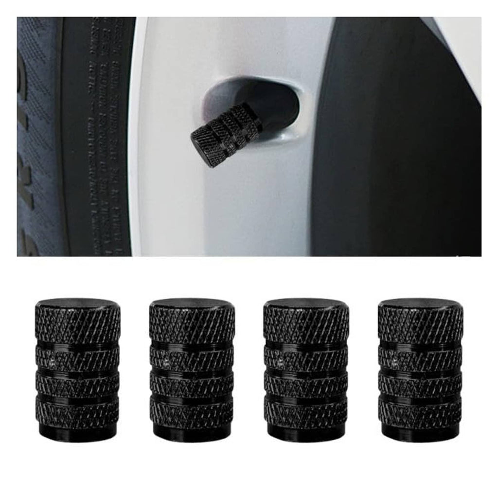 Four black ribbed tire valve stem caps with one cap on a wheel valve