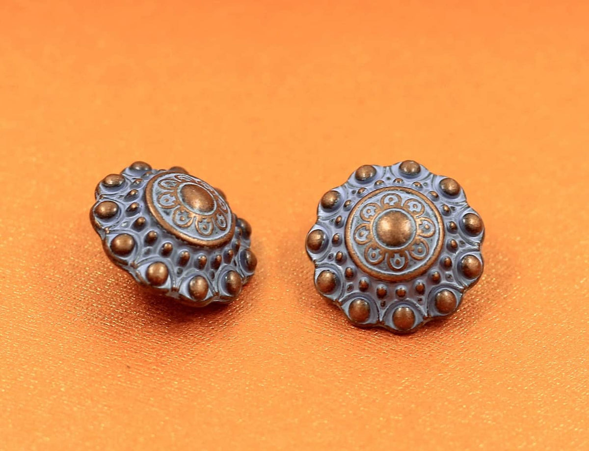 Two blue engraved metal shank buttons with bronze-tone circular pattern and studded edge