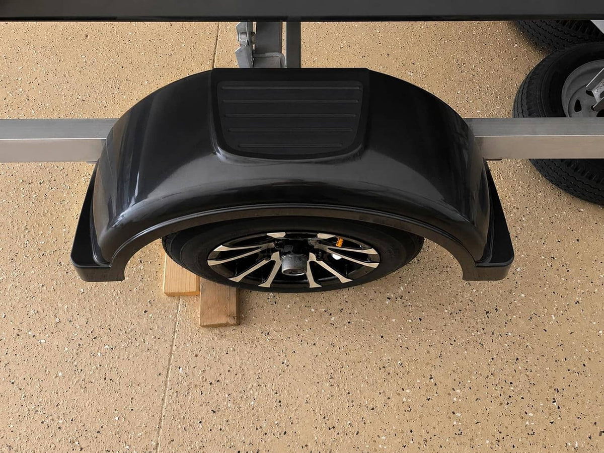 Black wheel-guard trailer fender mounted over a wheel on a support platform