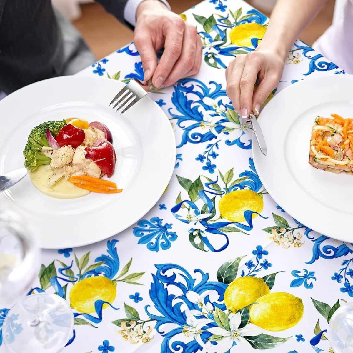 White tablecloth with blue floral and yellow lemon design, plates arranged on top