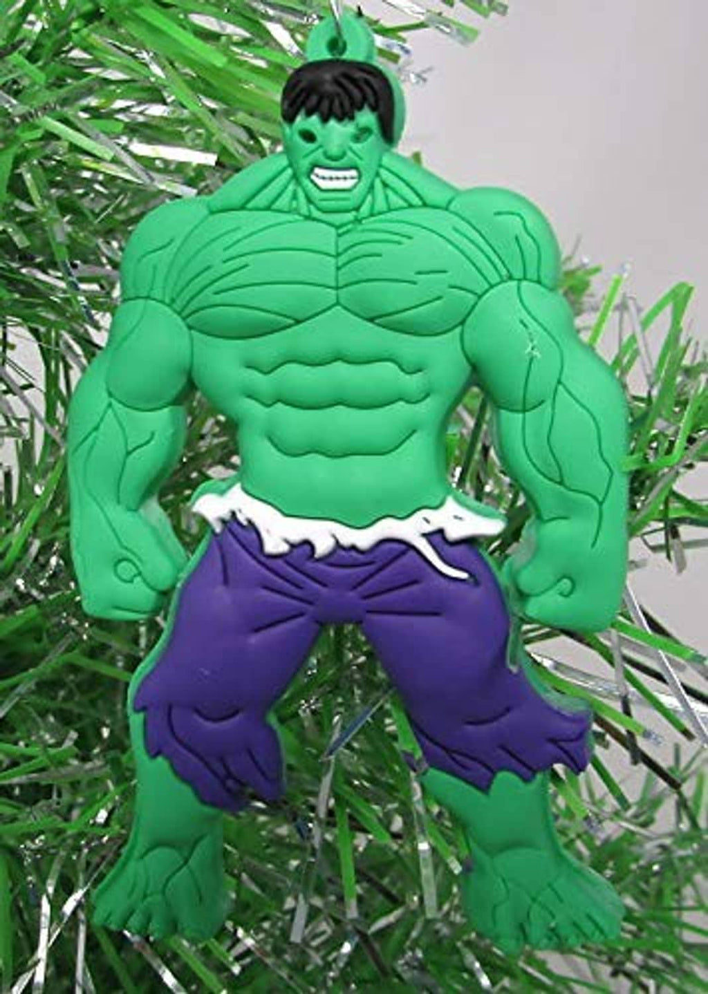 Green Hulk-style shatterproof Christmas ornament, hanging front view with purple shorts.
