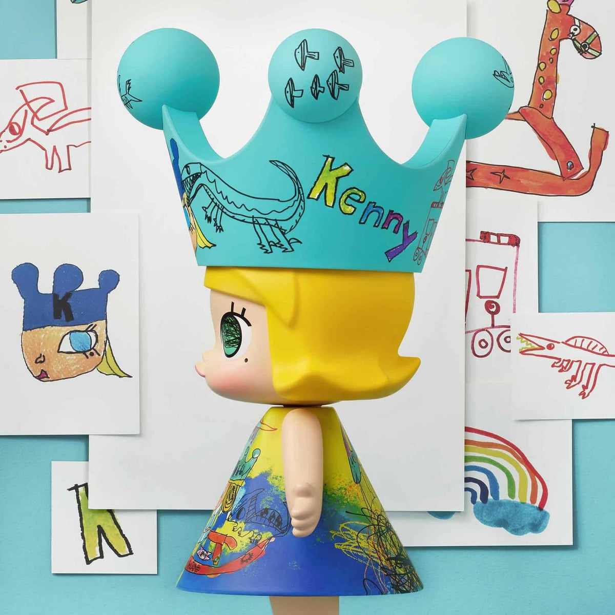 Royal Molly collectible doll standing side view, teal crown and yellow hair with printed dress
