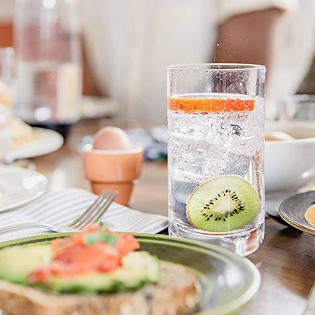 Tall glass of sparkling water with kiwi slice and condensation