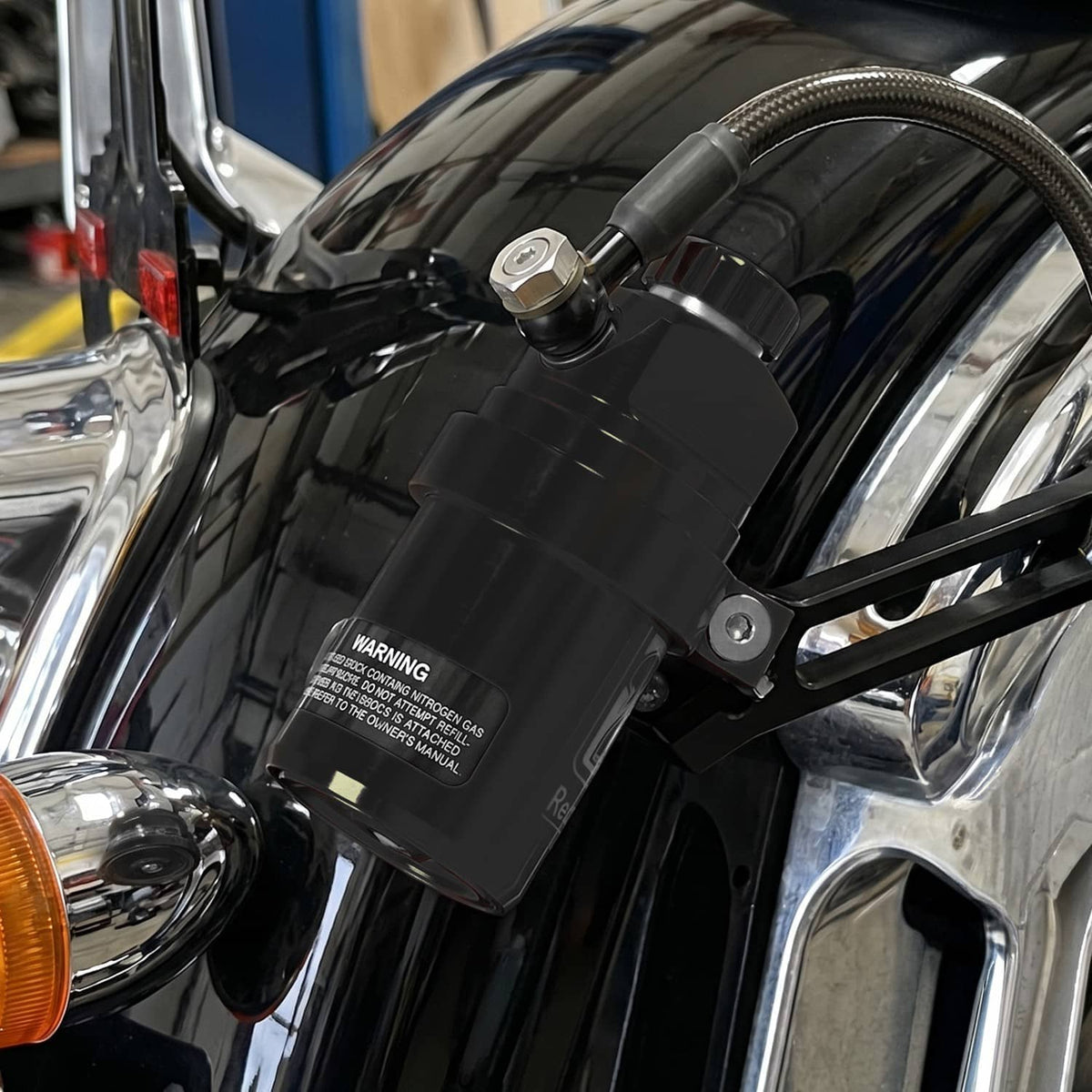 Remote reservoir shock reservoir and hose connection with mounting hardware on motorcycle