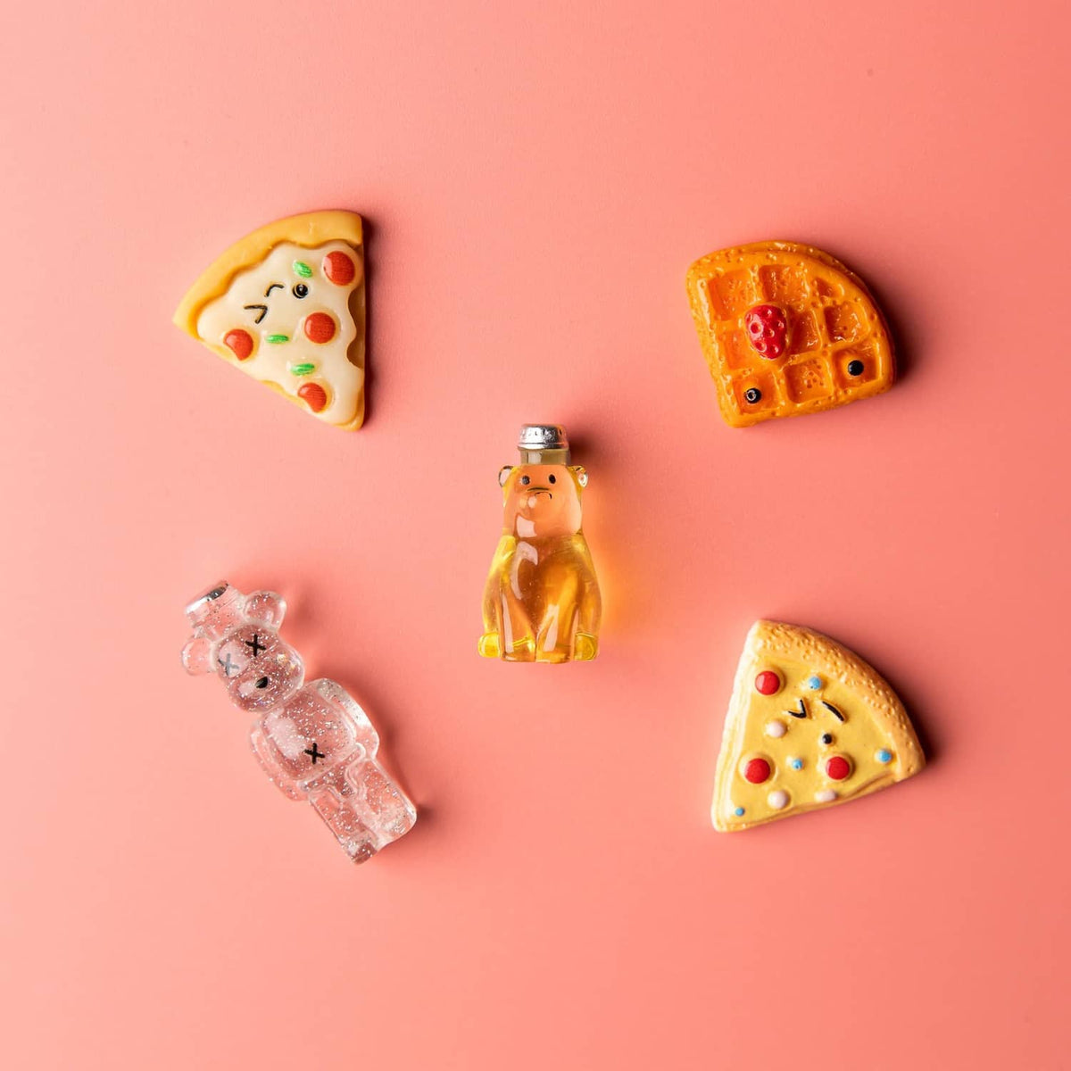 Small set of resin food charms: pizza slice, heart, bear figure, and cookie shapes