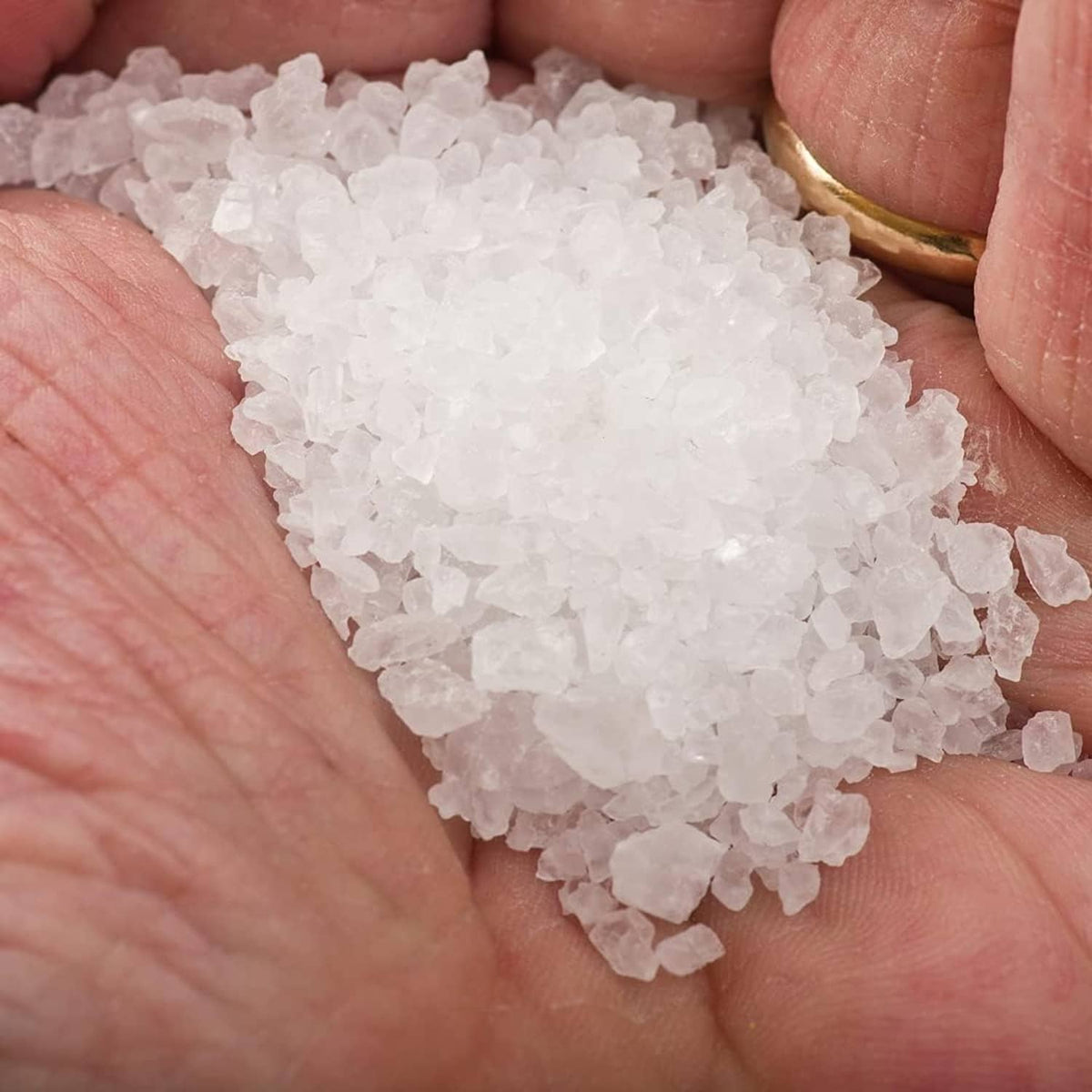White fleur de sel sea salt crystals held in hands
