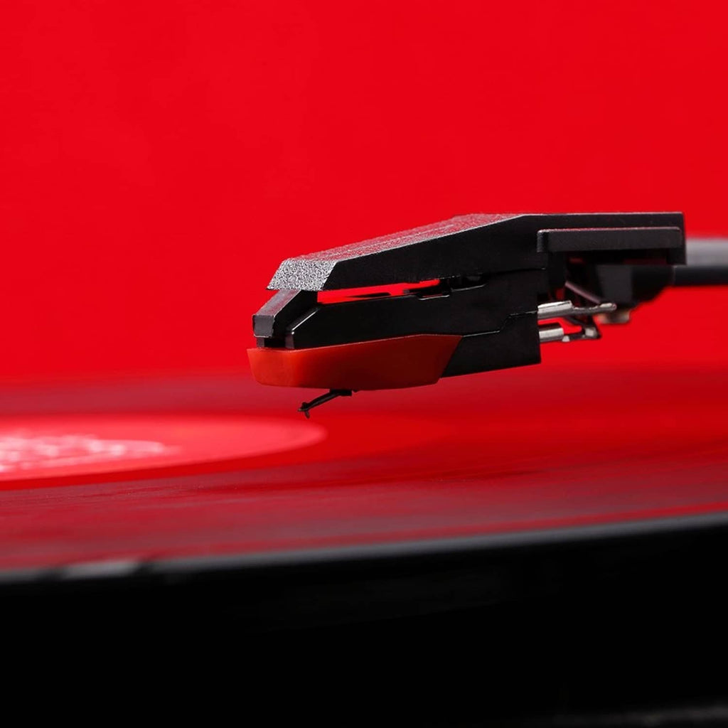 Stylus cartridge on a turntable tonearm above a red record surface