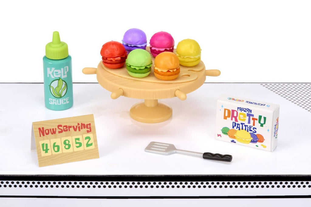 Beige pedestal tray with colorful mini burgers, sauce bottle and patty package pieces
