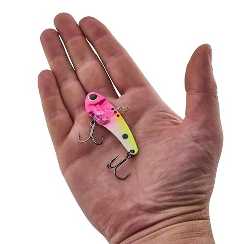 Small blade bait fishing lure in hand, pink and lime with treble hooks