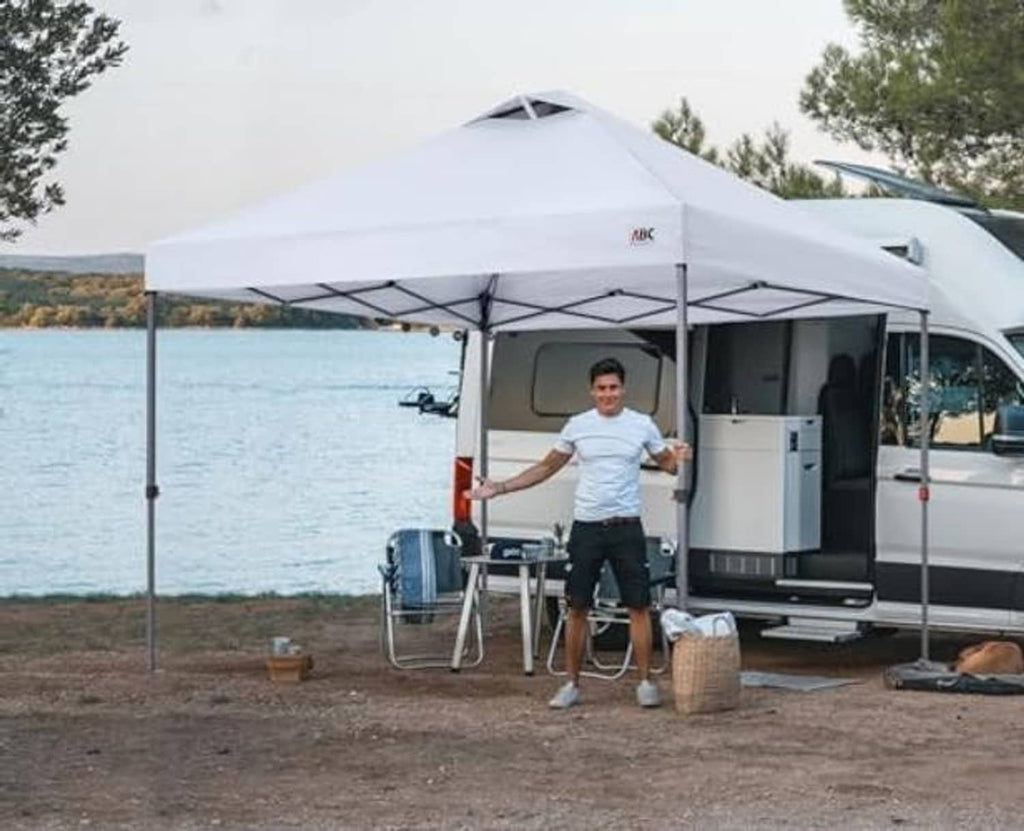 White pop-up canopy top on frame outdoors, with vented peak