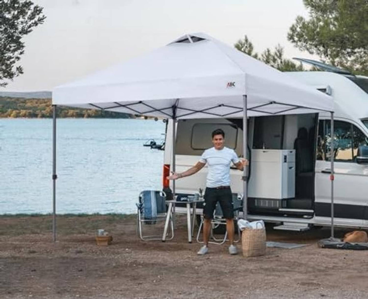 White pop-up canopy top on frame outdoors, with vented peak
