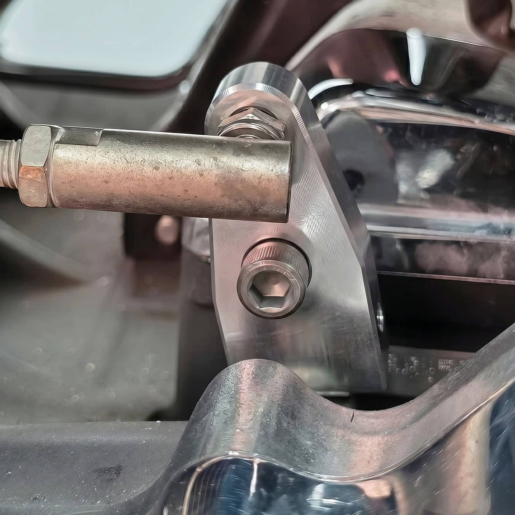Silver metal bracket and fasteners installed on motorcycle near engine components