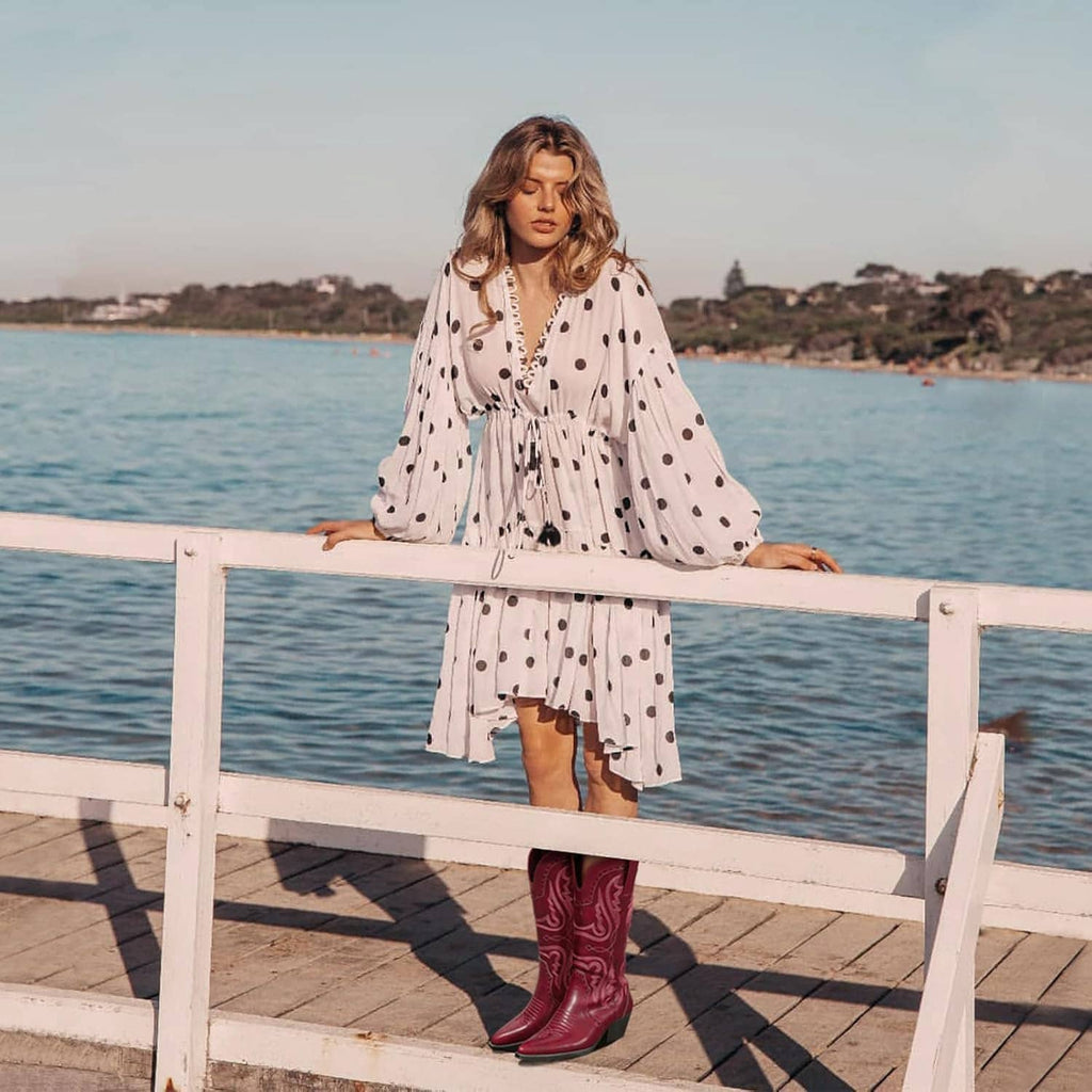 Women’s mid-calf cowboy boots with western embroidery, styled with a patterned dress