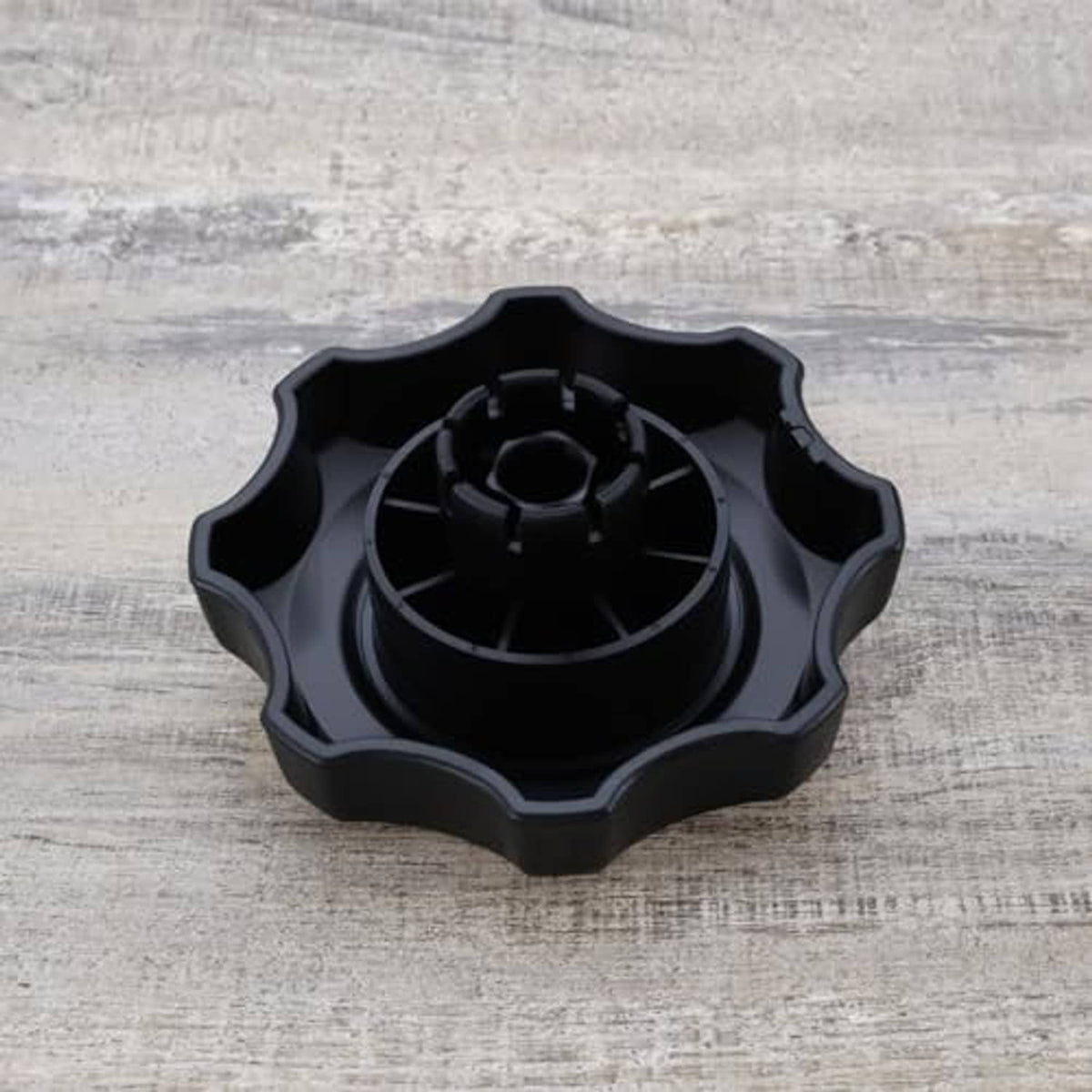 Black car seat adjustment knob underside with circular gear pattern