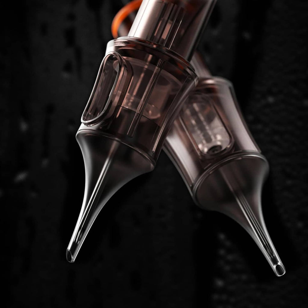 Black tattoo cartridges with clear chambers and needle tips, close-up pair