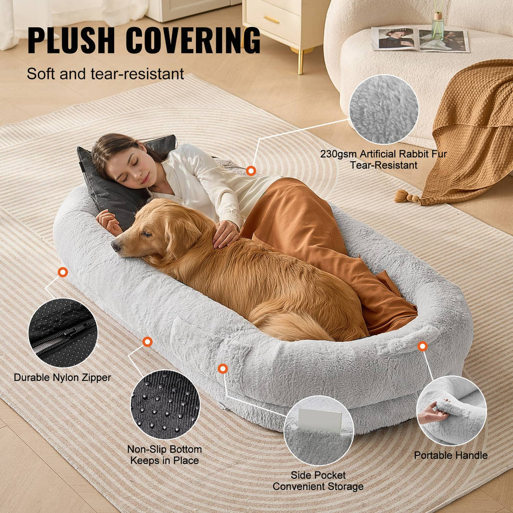 Grey plush oval dog bed with zippered cover, side pocket, and portable handle.