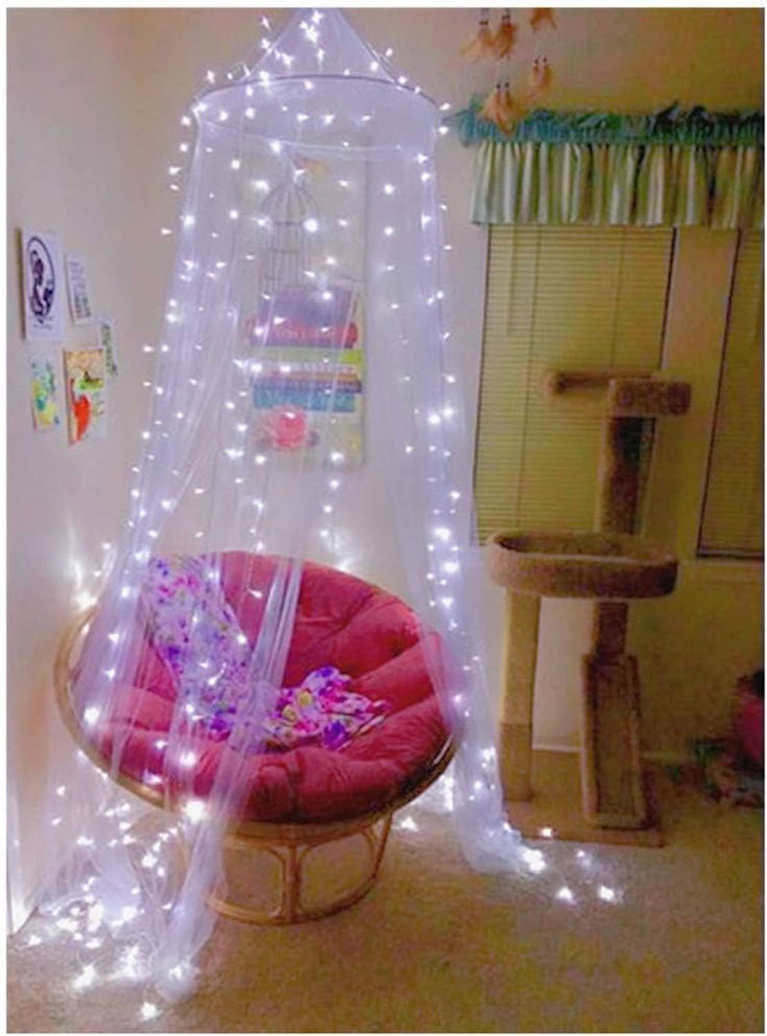 Sheer pink canopy mosquito net with string lights inside