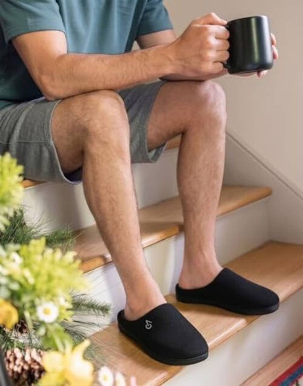 Men’s black memory foam house slippers on feet, gray inner lining visible
