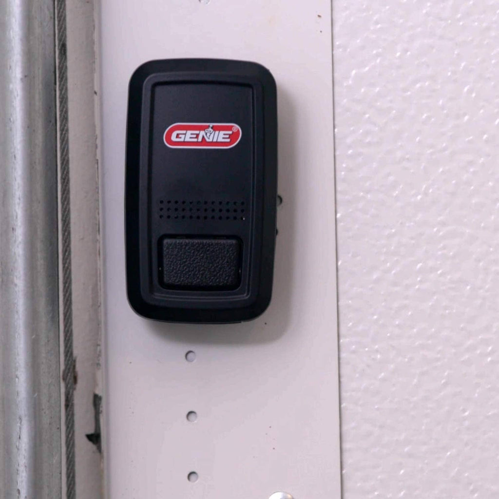 Genie door position sensor with textured button, mounted on wall