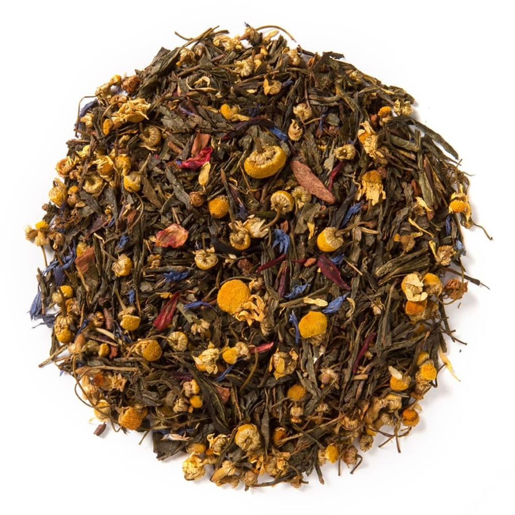 Pile of loose-leaf green tea with visible dried cinnamon pieces and herbs
