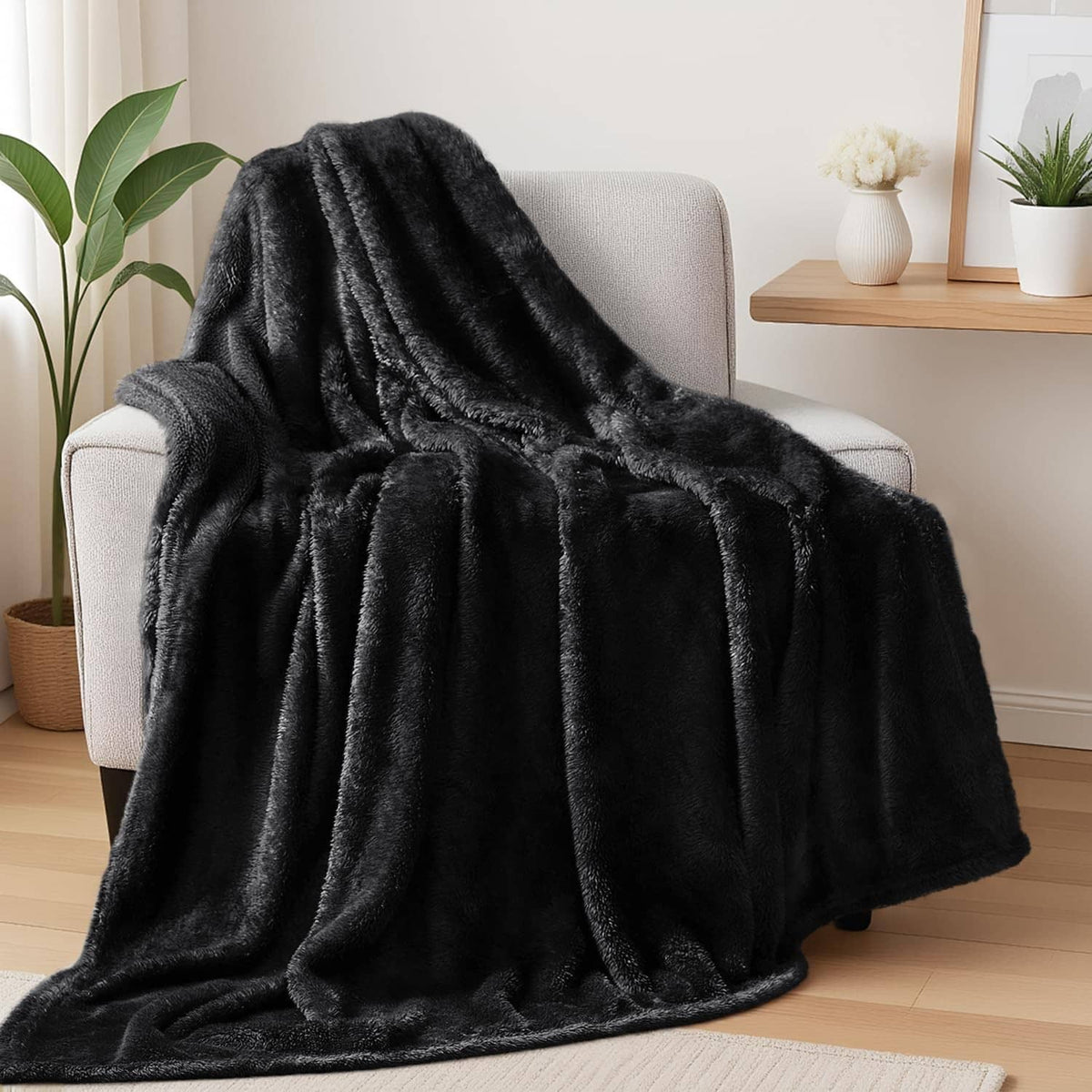 Black plush fuzzy fleece throw blanket draped over an armchair