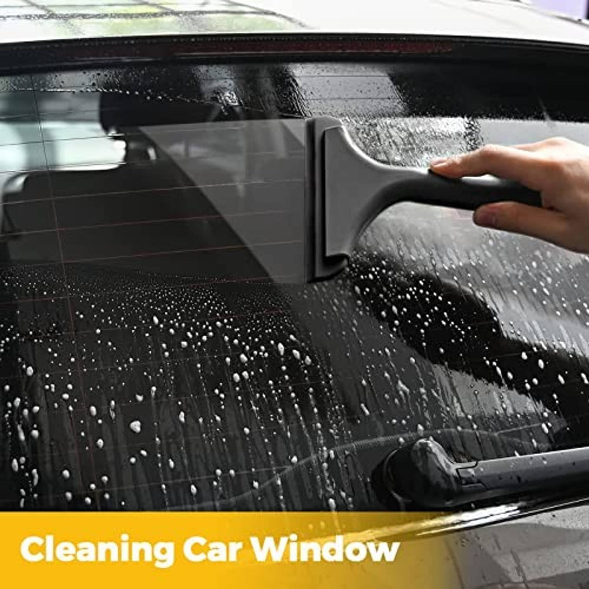 Black squeegee tool wiping water off a car window pane.