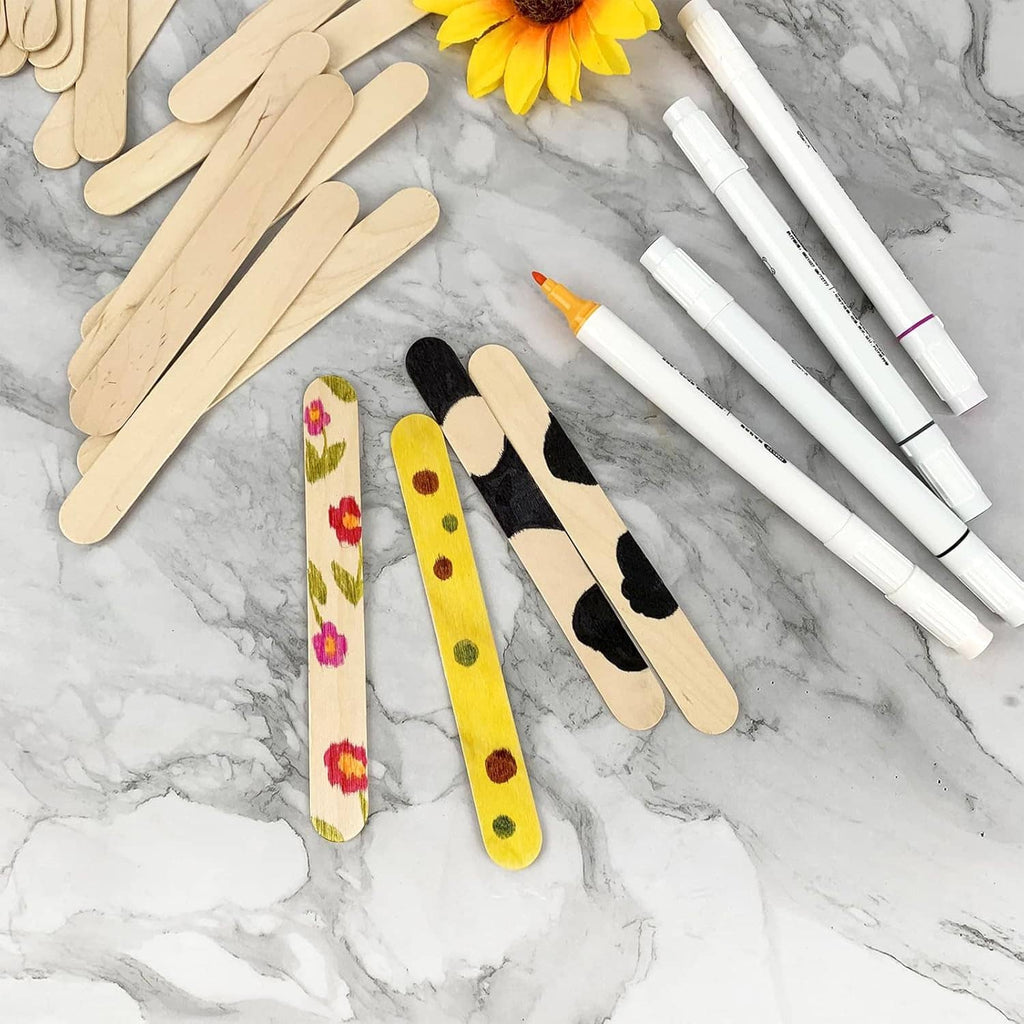 Light wood craft sticks with painted designs and markers