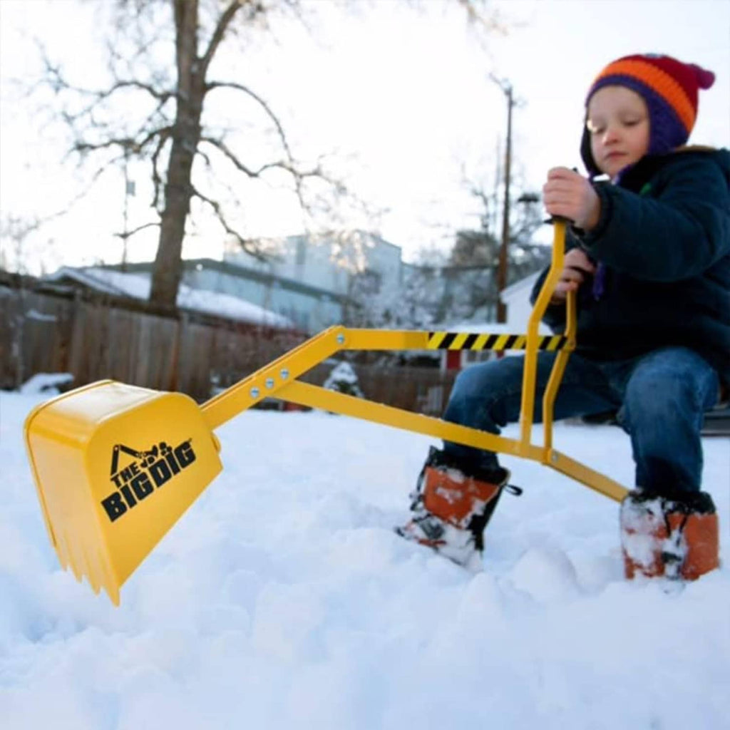 Yellow outdoor digger playset with digging bucket and black seat, used in snow.