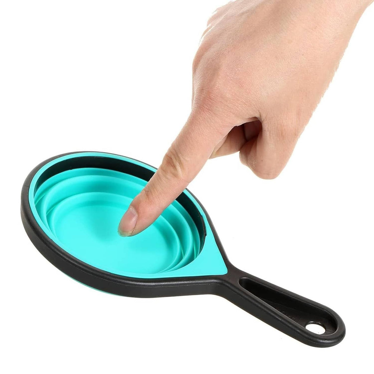 Turquoise collapsible silicone measuring cup with black handle, held by a hand