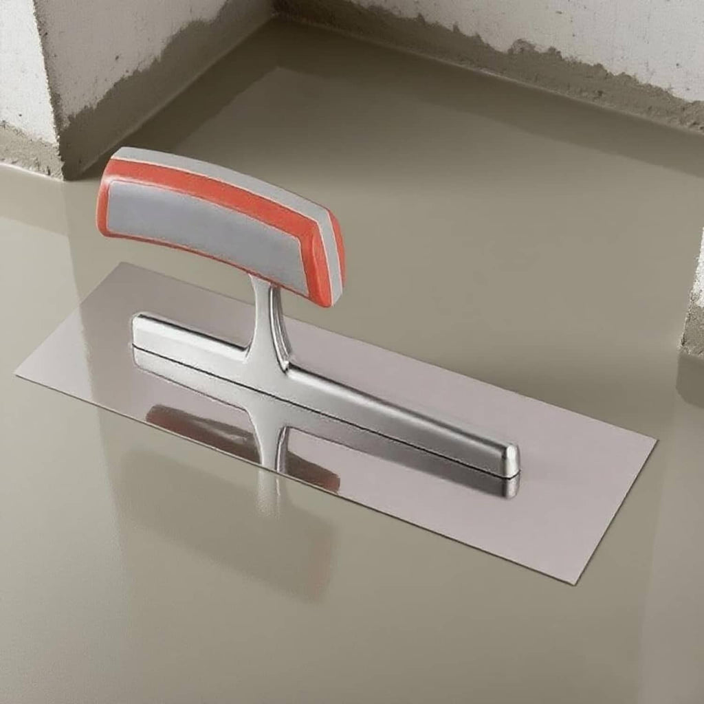 Stainless steel trowel smoothing tool with red handle on concrete surface.