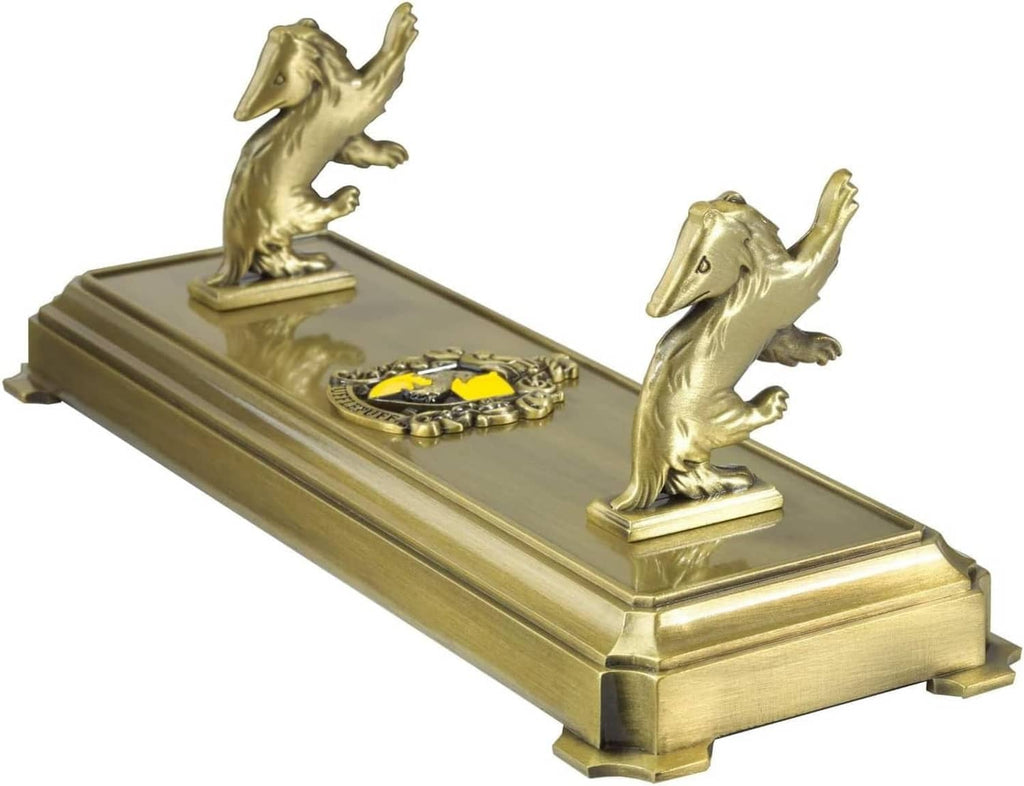 Gold-tone wand stand with paired badger statues and central yellow-gold emblem design