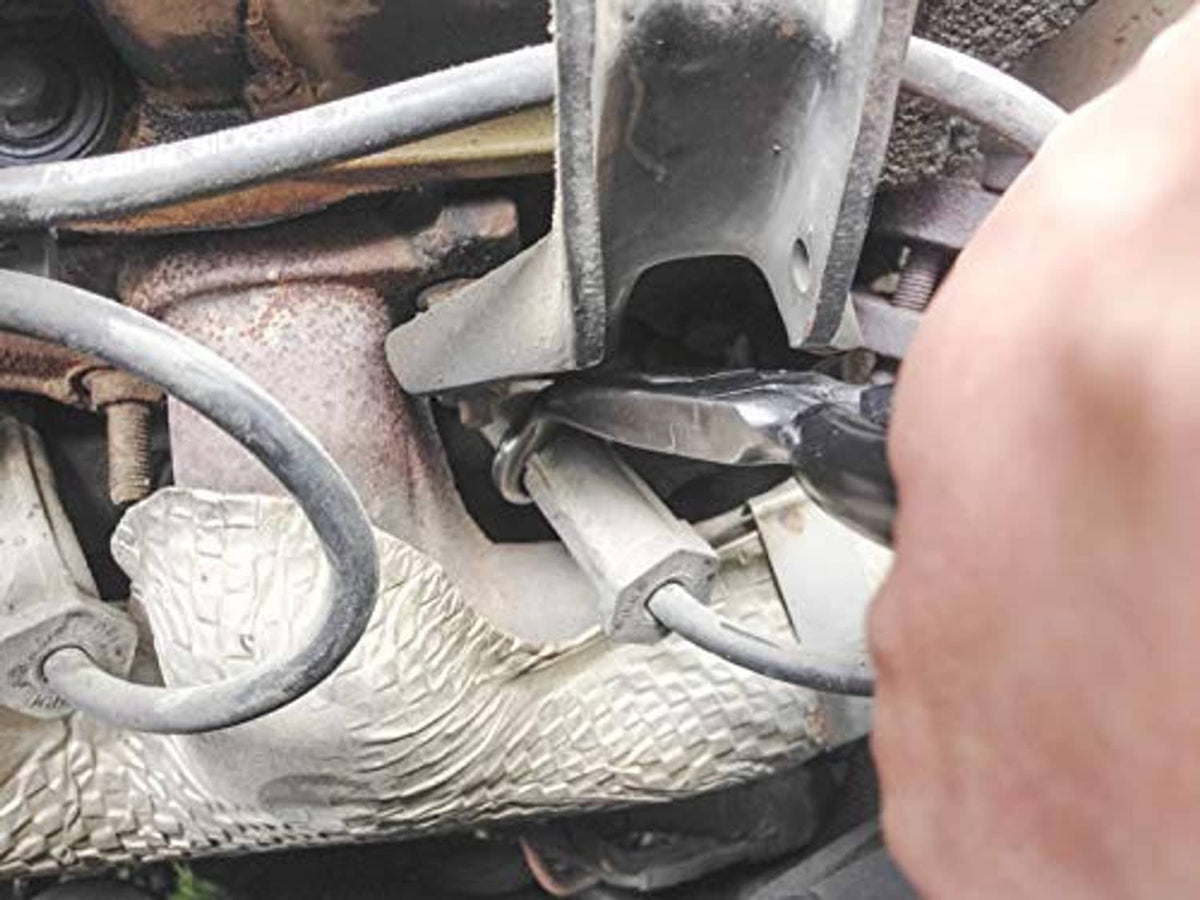 Spark plug boot removal pliers gripping a rubber boot near the spark plug