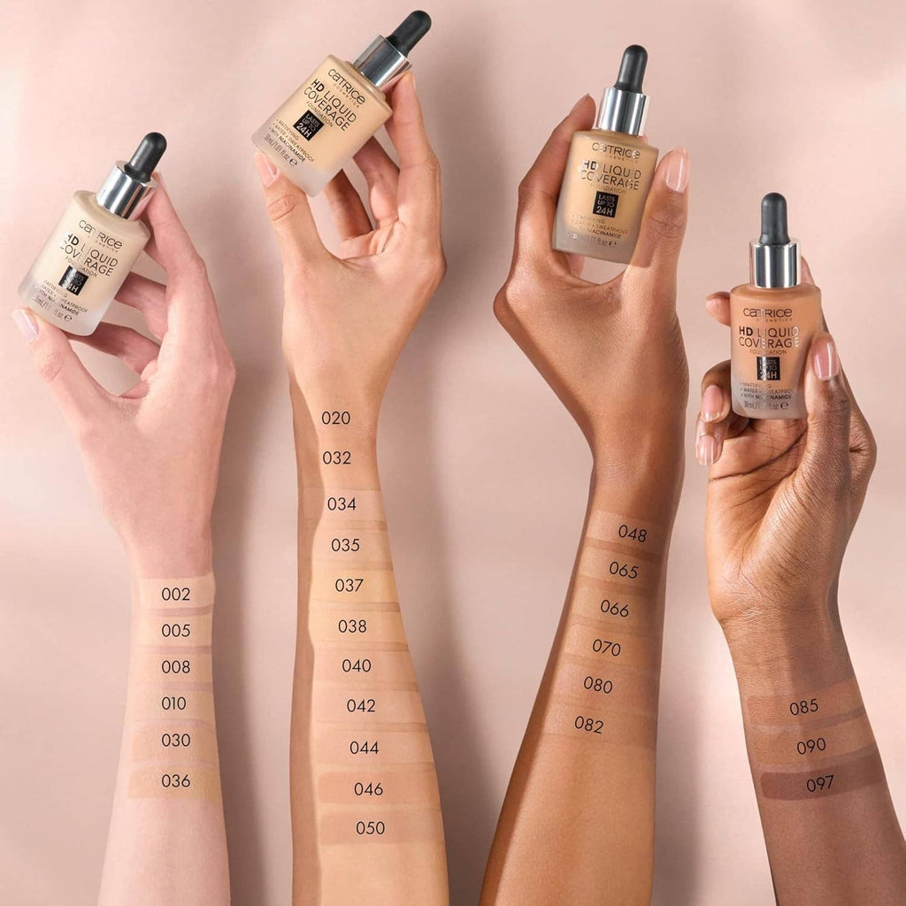 Hands holding liquid foundation bottles with beige shade swatches on skin