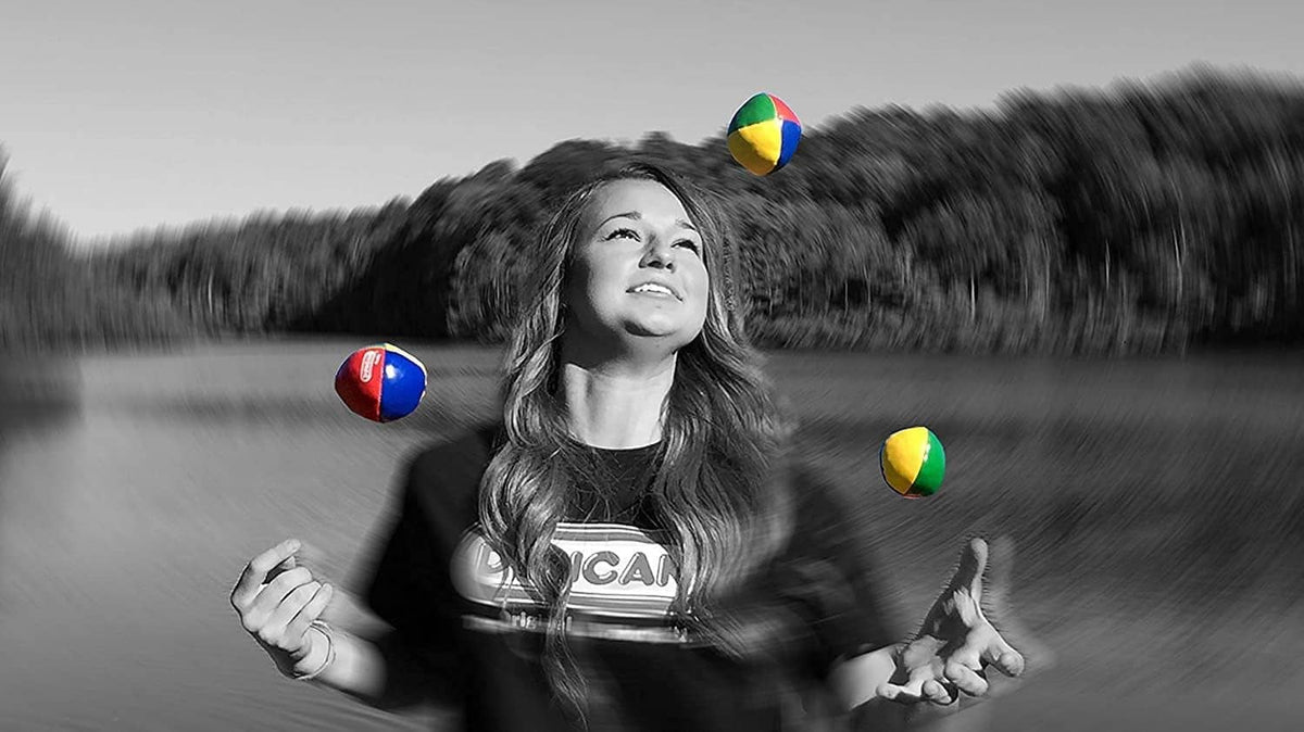 Multicolor vinyl juggling balls in the air, including red, blue, green, and yellow.