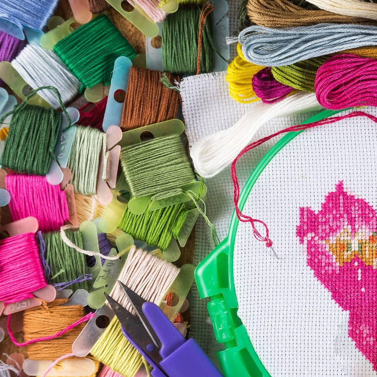 Embroidery floss organizer clips with multicolor threads and a cross-stitch fabric piece