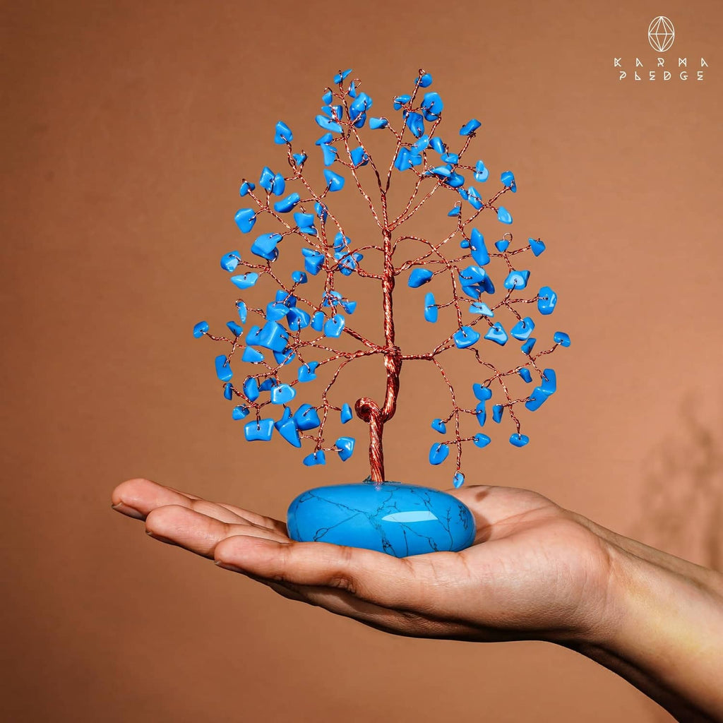 Turquoise crystal tree ornament with blue stone base held in hands, blue crystal chips