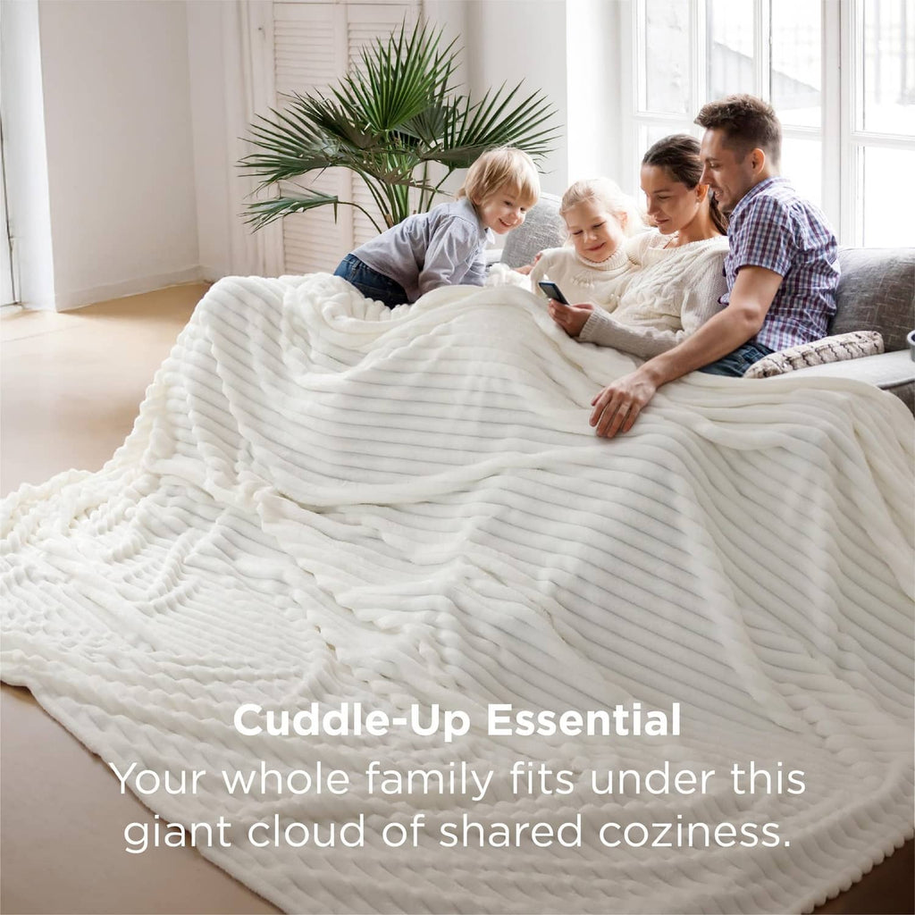 Off-white chunky fleece blanket spread across a sofa with ribbed wave texture