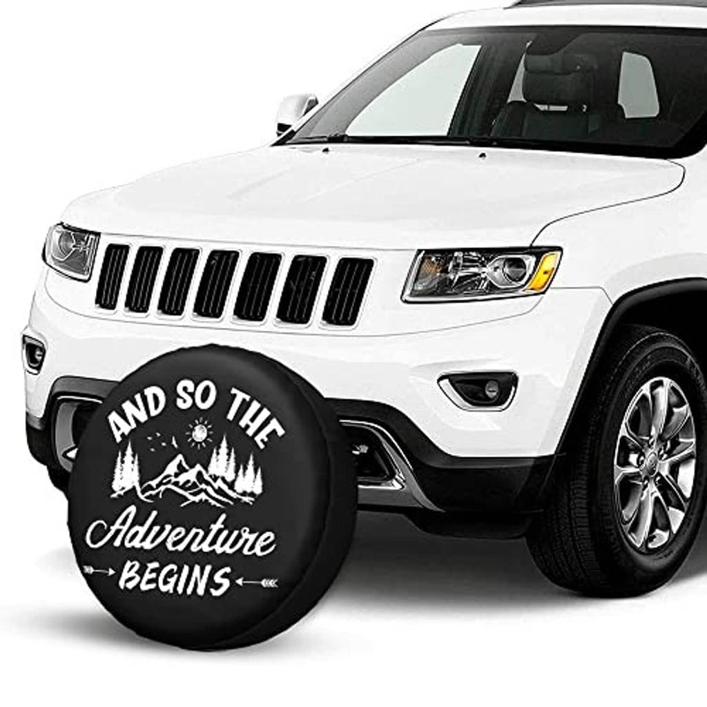 Black spare tire cover with “Adventure Begins” graphic on vehicle front wheel