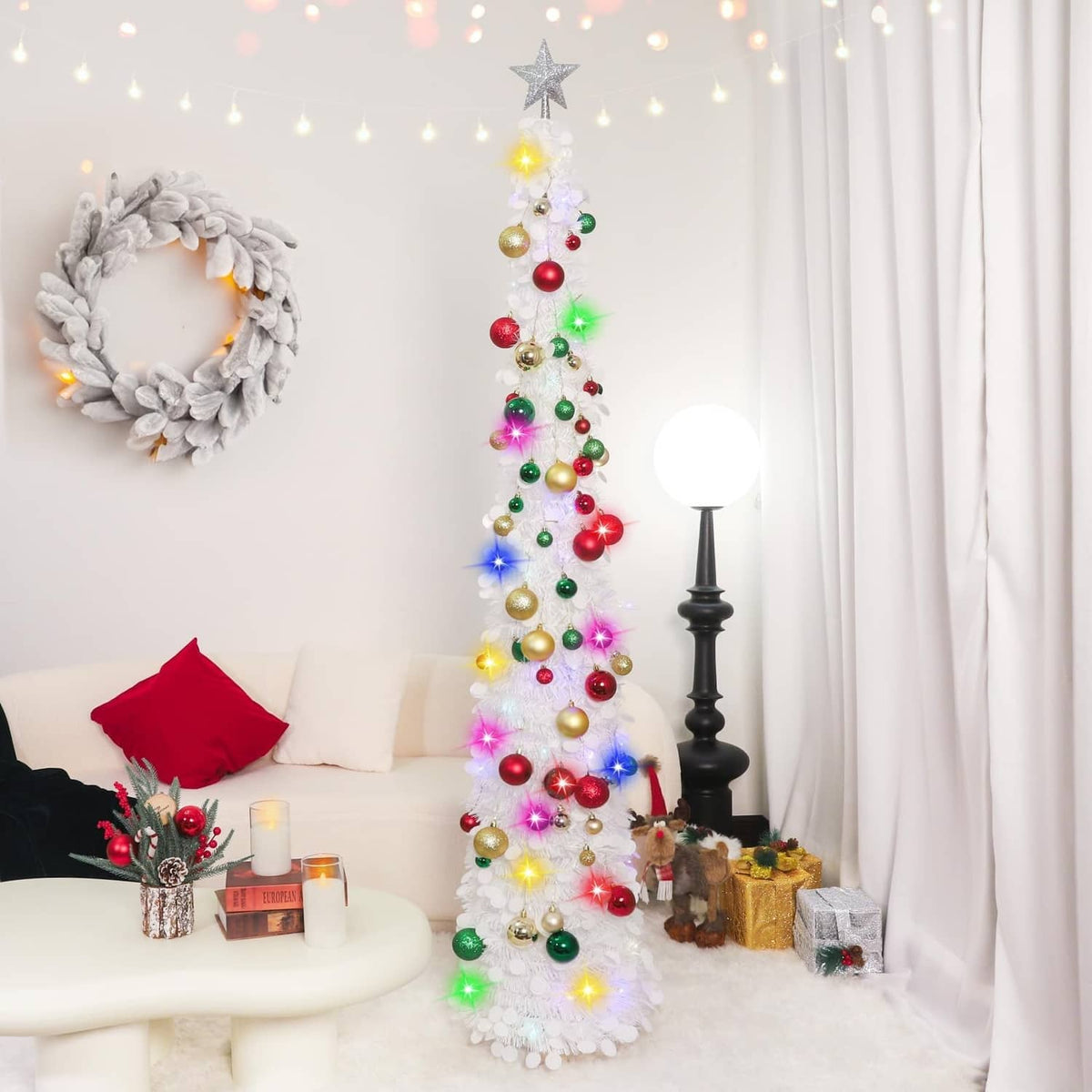 White pop-up Christmas tree with star topper, colorful lights, and red green gold ornaments