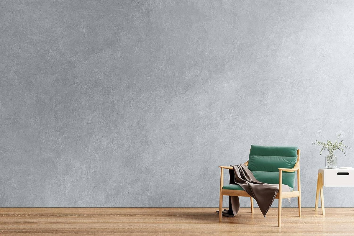 Gray concrete-textured interior wall with a chair and small side table